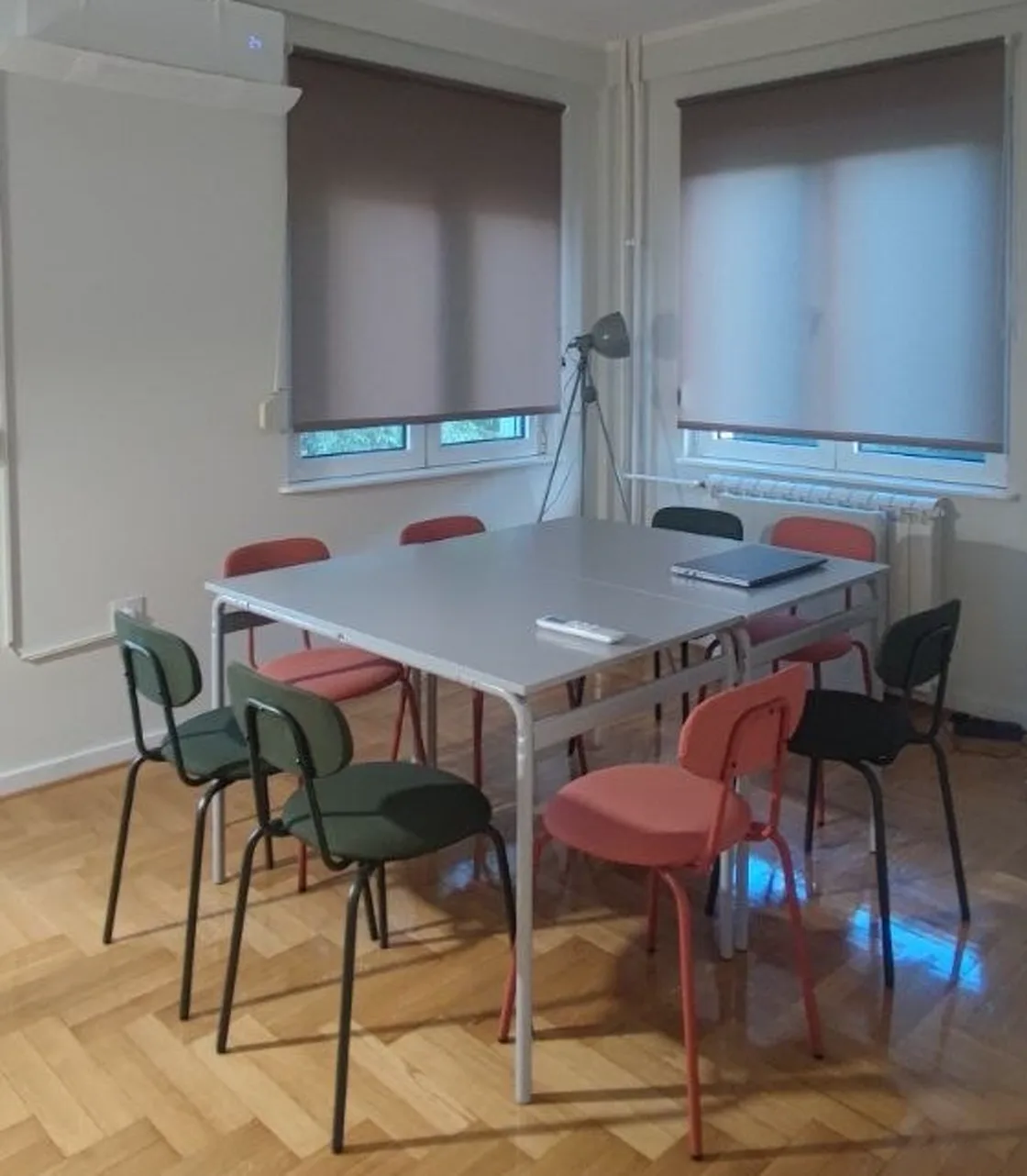 Meeting table and chairs beside two windows at LIMUN coworking in Novi Sad